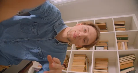 Vertical closeup portrait of young handsome caucasian male blogger streaming Video stock 114450606