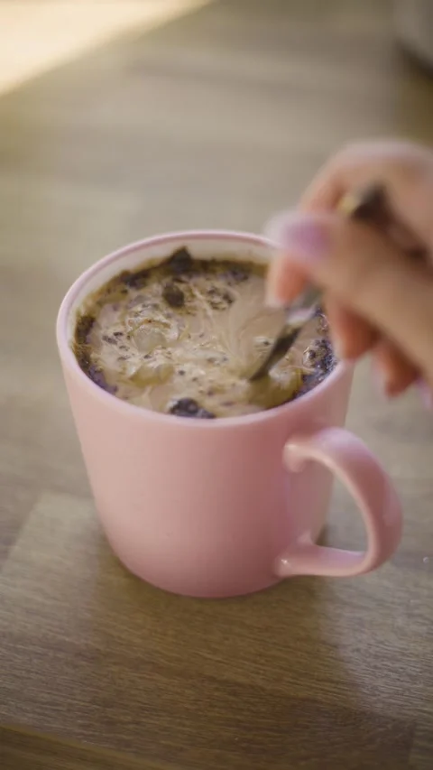 Vertical closeup of pouring white sugar into pink coffee mug reel video Stock Footage 342240674
