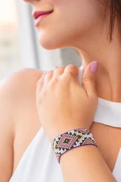 Vertical closeup of a purple patterned bead loom bracelet on a Caucasian female' Stock Photos