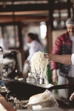 Vertical closeup shot of a chef making noodles with a blurred background Stock Photos