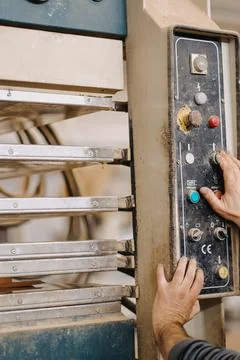 Vertical closeup shot of hands working the buttons of an industrial machine Stock Photos