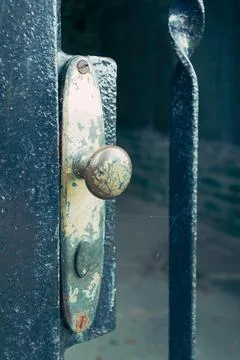 Vertical closeup shot of an old and rustic knob of a steel gate Foto stock