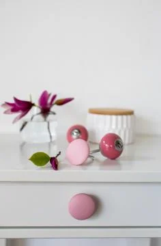 Vertical closeup shot of pink knobs and flowers on a white table Foto stock