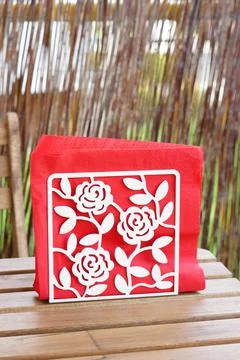 A vertical closeup shot of triangled red napkins with a white pattern of rose Foto stock