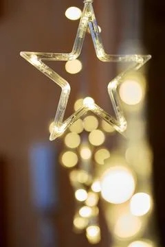 Vertical closeup of a star led string light on bokeh lights background Stock Photos