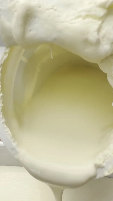 Vertical - Closeup of thick double cream slowly pouring from an open carton. Stock Footage 304523612