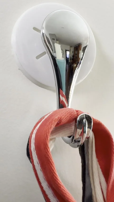 Vertical - Closeup of tops of cook’s aprons being hung from a stuck-on hook. Video stock 302909892