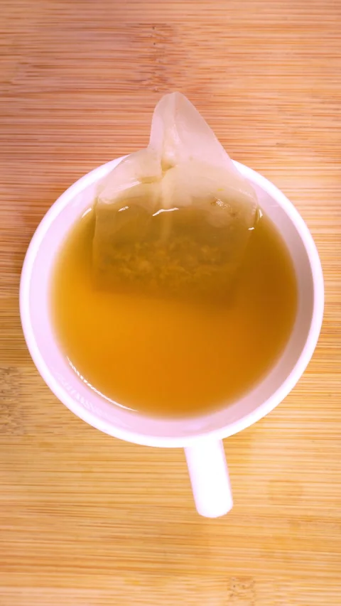 Vertical - Closeup transition from a stirred cup of coffee to infusing tea. Stock-Footage 301247530