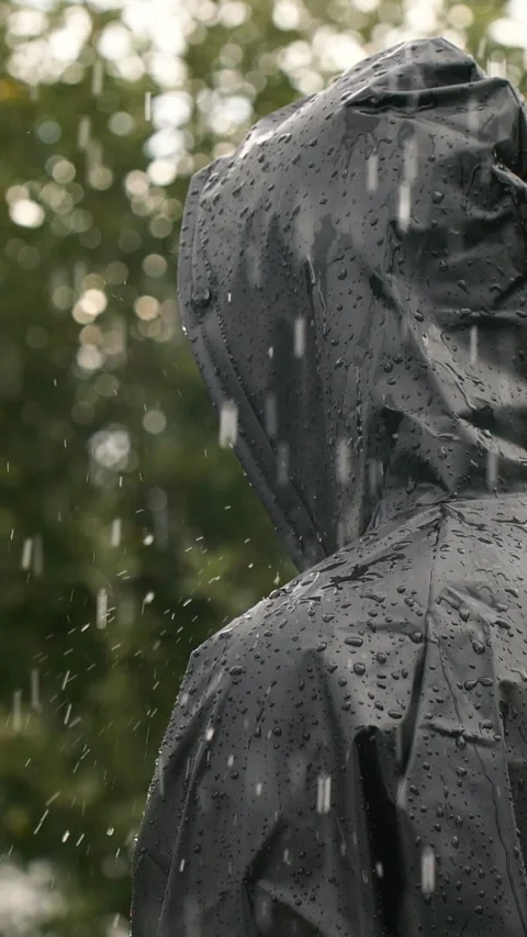 Vertical closeup video of unrecognizable person in heavy rain, man in black coat Stock Footage 276592169