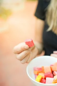 Vertical closeup view of one candy holded by unrecognizable white woman with som Foto stock
