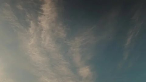 Vertical cloud columns slicing dusk sky with warm highlights. Dynamic Stock Footage 323437488