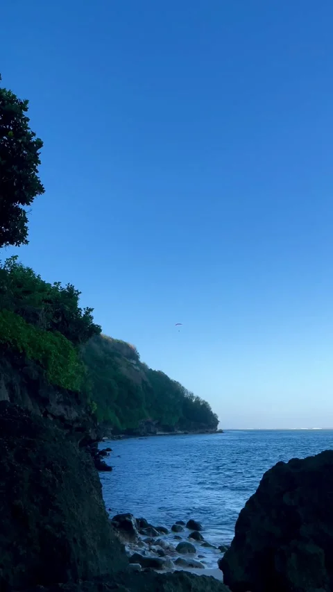 Vertical Coastal Cliff Framing Blue Ocean and Sky in Bali Stock Footage 337336209