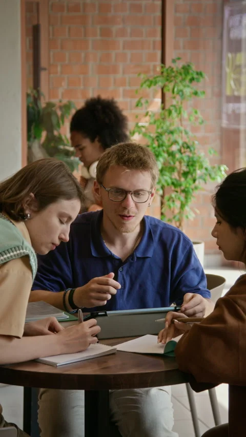 Vertical of College Students Collaborating with Tablet during Group Study Stock Footage 342128641