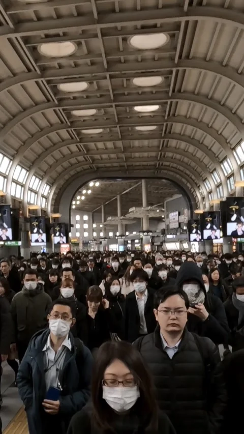 Vertical commuters walking through hallway under bright lights Stock Footage 312351413