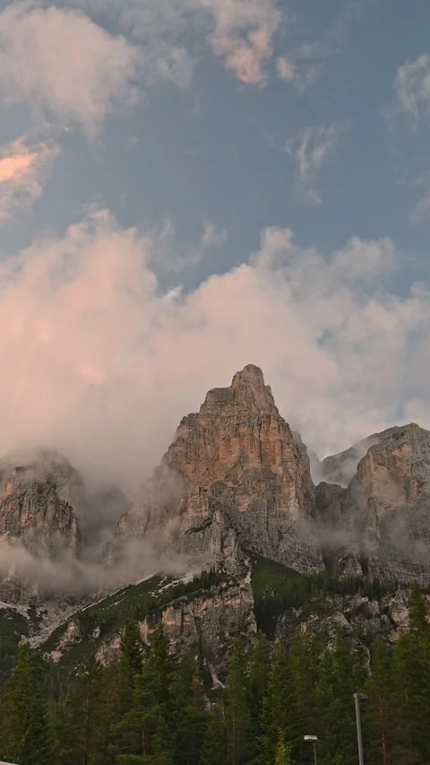 Vertical composition of Dolomite peaks under pink sunset clouds Видео 318949396