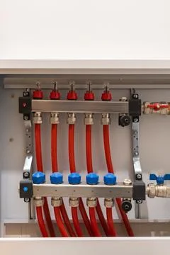 Vertical composition of heating manifold with multiple connected pipes Stockfoto's