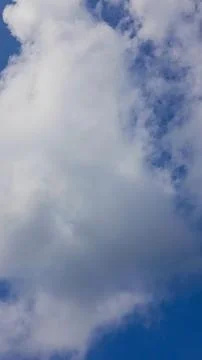 Vertical composition of a large, dramatic white cloud set against a deep blue sk 库存照片