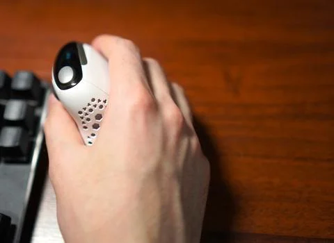 Vertical computer mouse in the hands of a programmer near the keyboard on a.. 写真素材