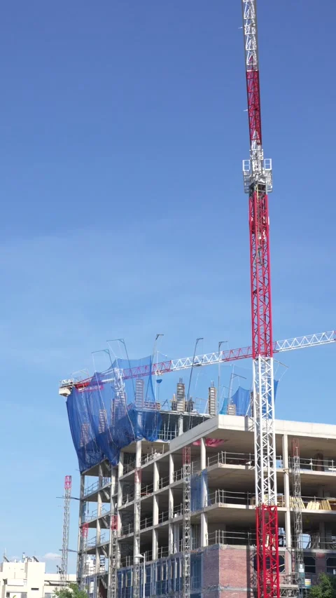 Vertical Construction Crane and Residential Building Development Against Blue Stock-Footage 336012066