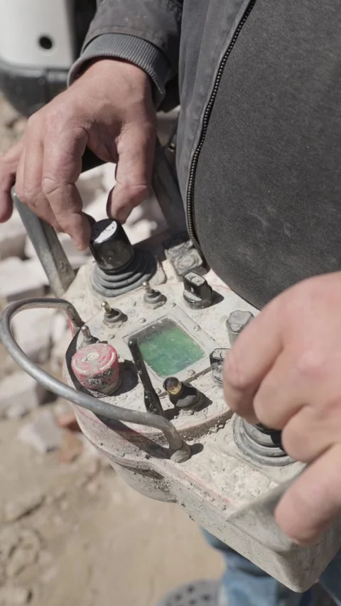 Vertical. Construction worker operating heavy machinery with a remote control Stockbeeldmateriaal 333647486
