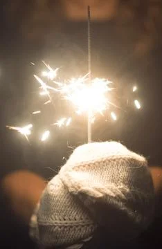 Vertical copy space image of hands holding a fire sparkler to celebrate new.. Stock Photos