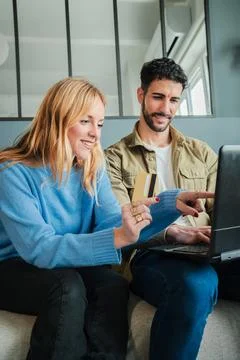Vertical. Couple using a laptop to make an online purchase with a credit card Stock Photos