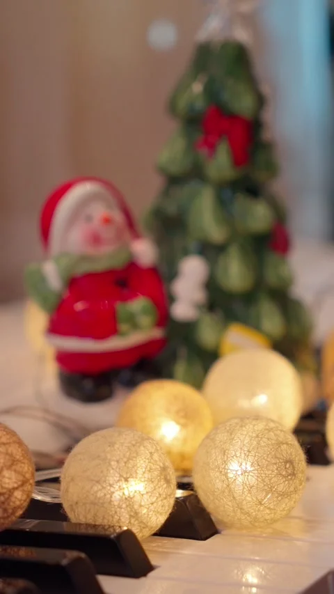 Vertical Cozy Christmas tree, warm garland and Snowman on Piano Stock-Footage 339525062
