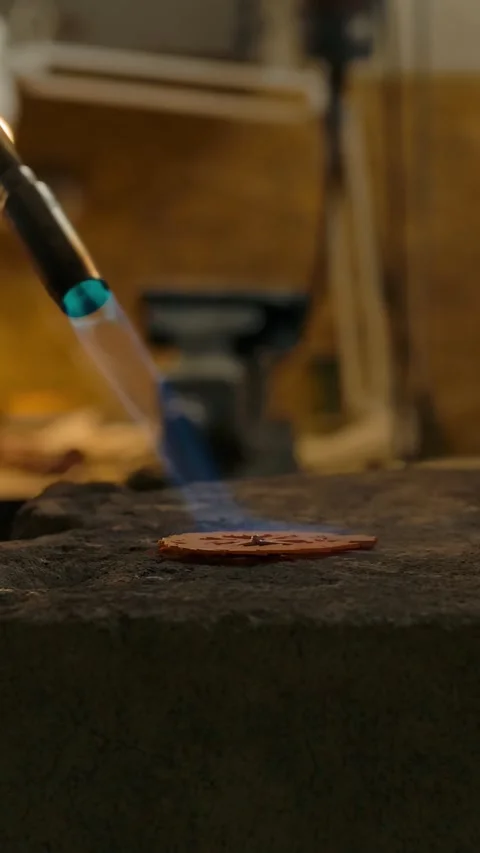 Vertical of The craftsman works with the part using a gas burner at high Stock Footage 276920386