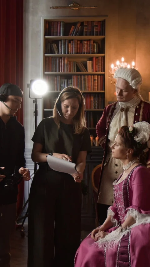 Vertical of Crew and Actors Discussing Script on 18th Century Movie Set Stock Footage 316719264