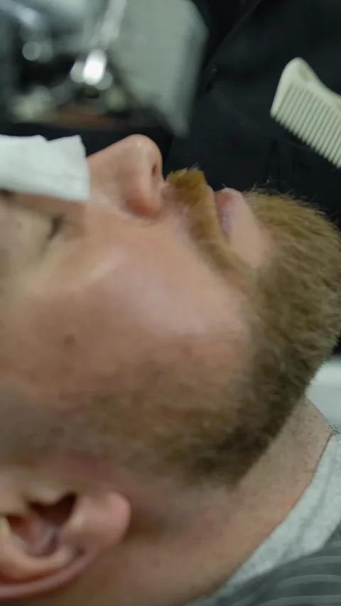 Vertical of Crop barber trimming beard of customer Stock Footage 276923369