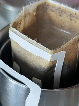 Vertical cropped close up of a drip coffee bag on a metal mug Stock Photos
