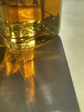 Vertical cropped close up of light and shadows of sun shining through a bottl Stock Photos