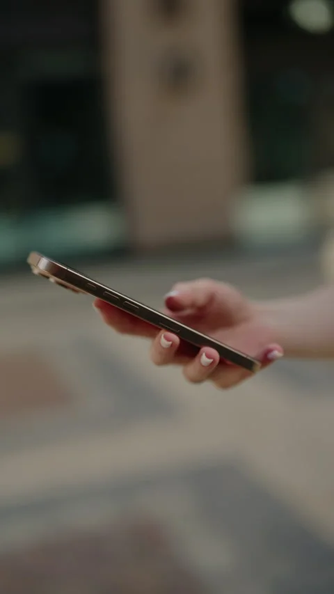 Vertical cropped shot of unrecognizable female hand using mobile phone, swiping Stock Footage 342756708