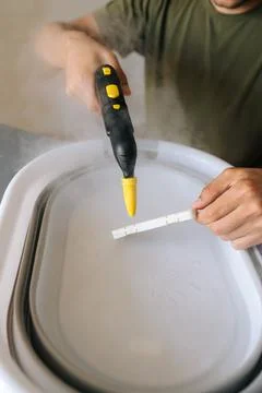 Vertical cropped shot of unrecognizable man using steam cleaner for sanitizing Stock Photos