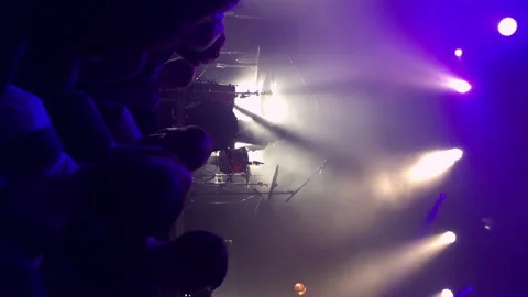 Vertical: crowd shakes their heads to the beat of the drummer on stage Stock Footage 231509996