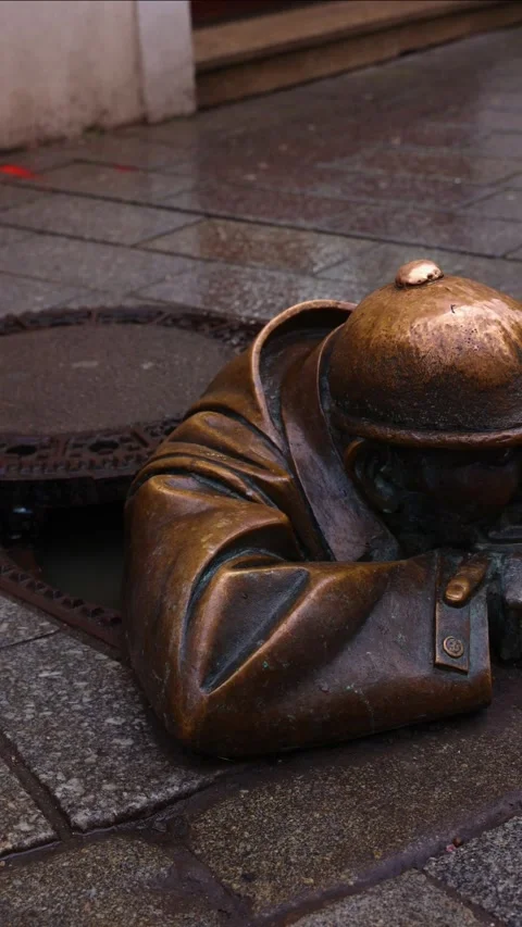 Vertical Cumil, the iconic man at work statue peeking from manhole in Brati.. Stock-Footage 303384204