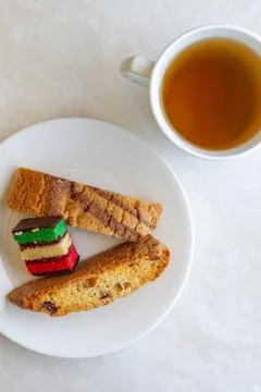Vertical cup of tea with biscotti and Italian rainbow cookie, overhead stil.. Stock Photos