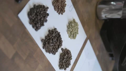 Vertical, Dark and light coffee beans are piled up for display on counter Stock Footage 240841653