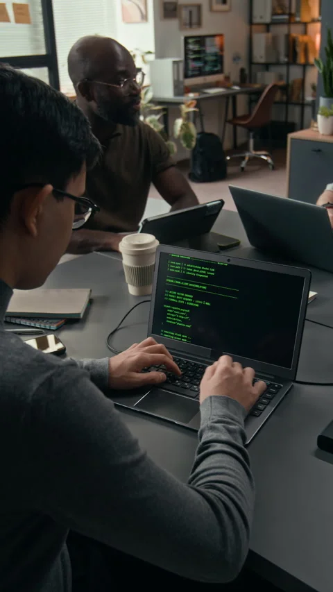 Vertical of Dark-Haired Young Programmer Writing Code on Laptop at Work Desk Stock Footage 329615395