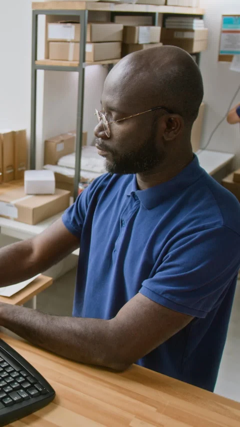 Vertical of Delivery Company Operator Preparing Shipping Documents on Computer Stock Footage 321490518