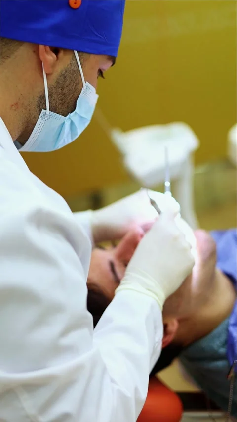 Vertical Dentist examining patient teeth with dental instruments Stock Footage 295784582