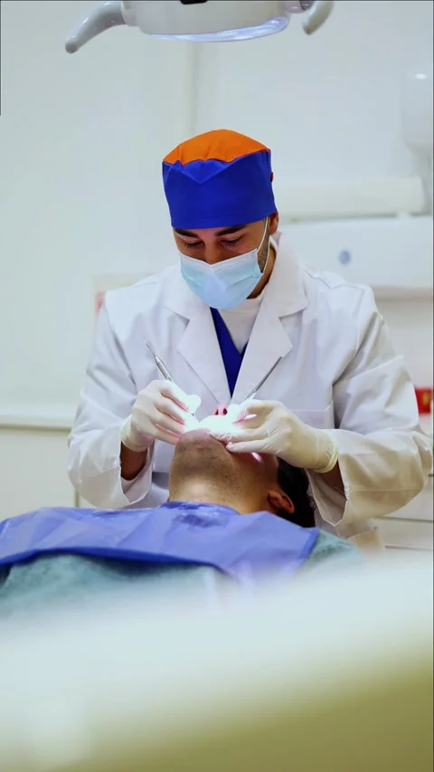 Vertical Dentist examining patient's teeth in dental clinic Stock Footage 295784579