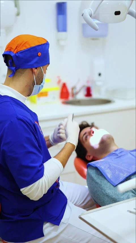 Vertical dentist explaining dental issues to patient during examination Stock Footage 295784566