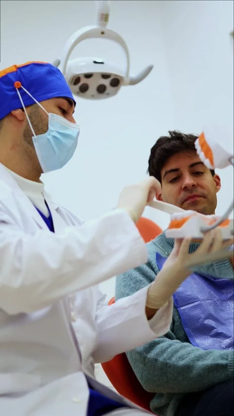 Vertical Dentist explaining teeth brushing using dental mold Stock Footage 295784609
