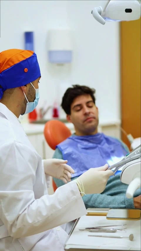 Vertical Dentist explaining treatment to patient in dental clinic Stock Footage 295784603