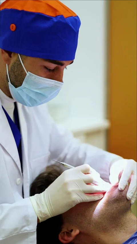Vertical Dentist performing a dental checkup on a patient Stock Footage 295784589