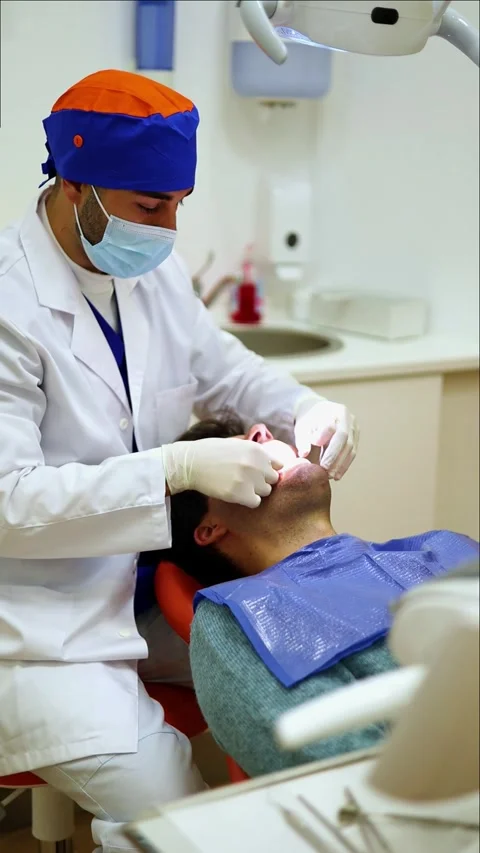 Vertical dentist using dental floss for cleaning patients teeth Stock Footage 295784613