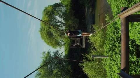 Vertical destroyed suspension bridge. River canyon in the wild Stock Footage 246958741