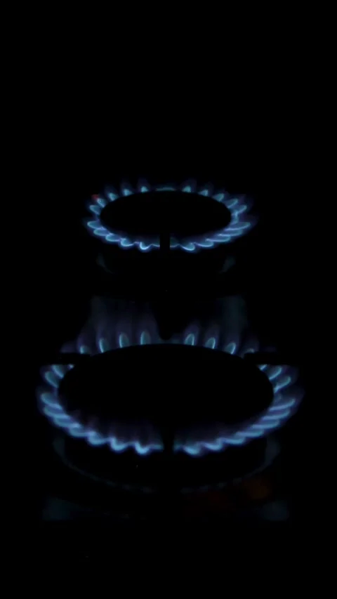 Vertical detailed view of a two natural gas stove ignition in the darkness Video stock 340242453