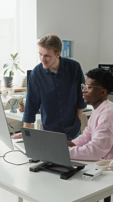 Vertical of Developer Reviewing Code of Colleague Pointing at Computer in Office Stock Footage 330132221